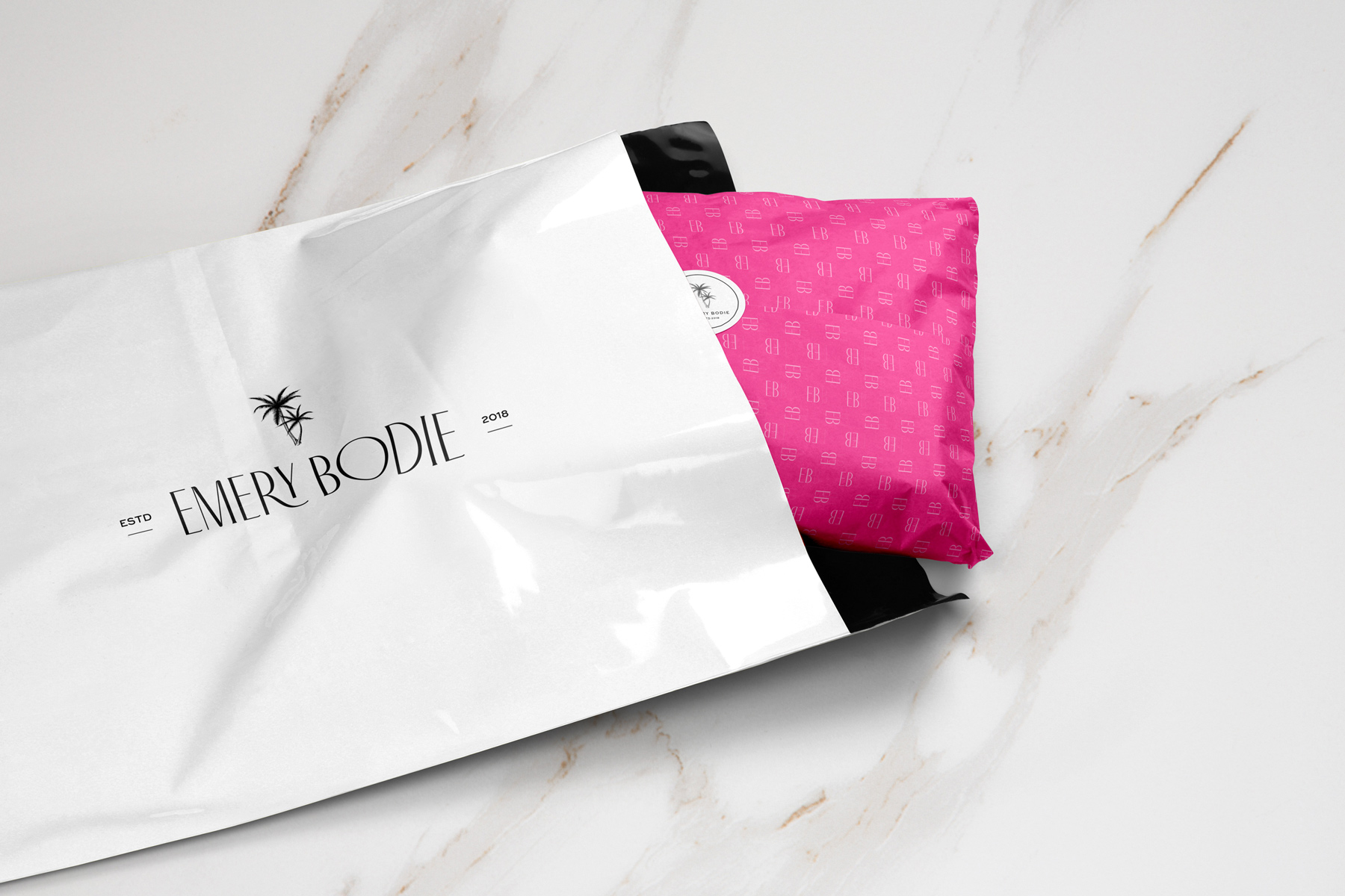 mockup of branded tissue paper and mailer bag for Emery Bodie